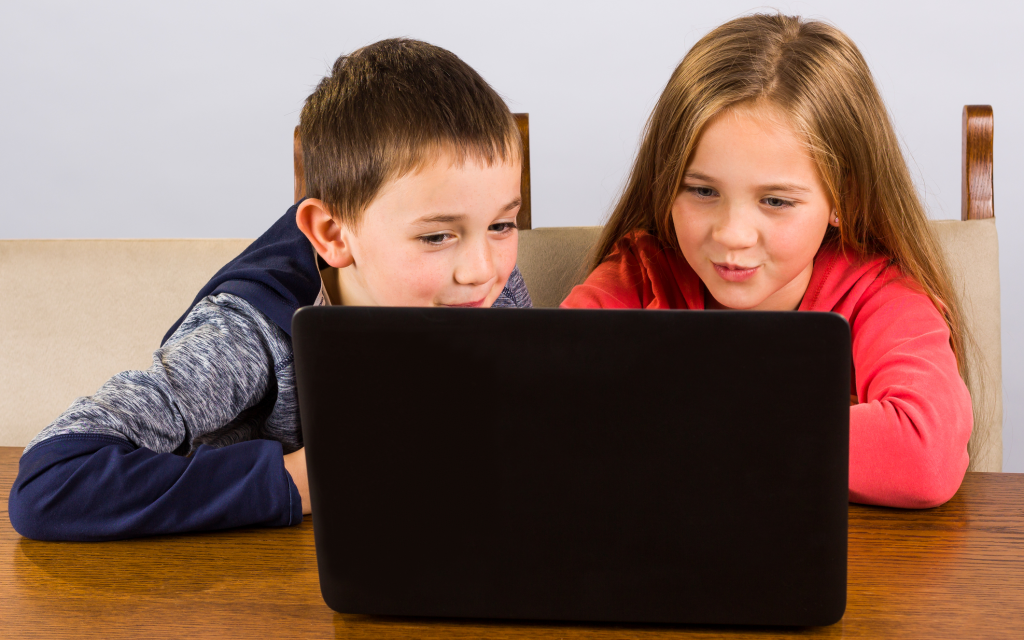 Young girl and boy excitedly looking at laptop computer - Adventures in NanaLand