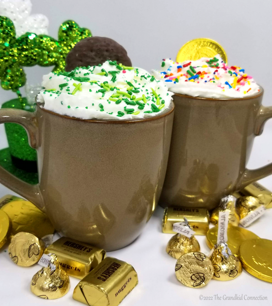 Two mugs of hot chocolate with whipped cream and sprinkles - St. Patrick's Day activities - Adventures in NanaLand