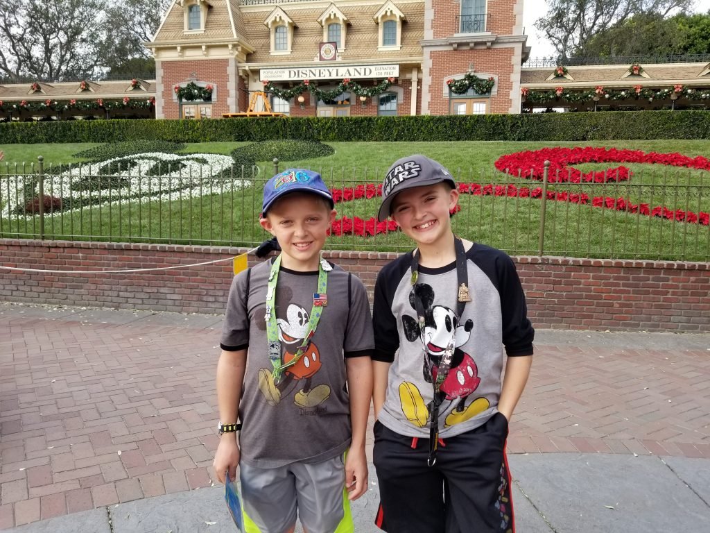 Boys stnding inside the Disneyland Maingate area - Beating the Disneyland Crowds - Adventures in NanaLand