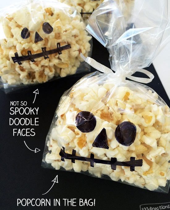 Plastic bags of popcorn with spooky faces drawn on bag - 100 Directions.com