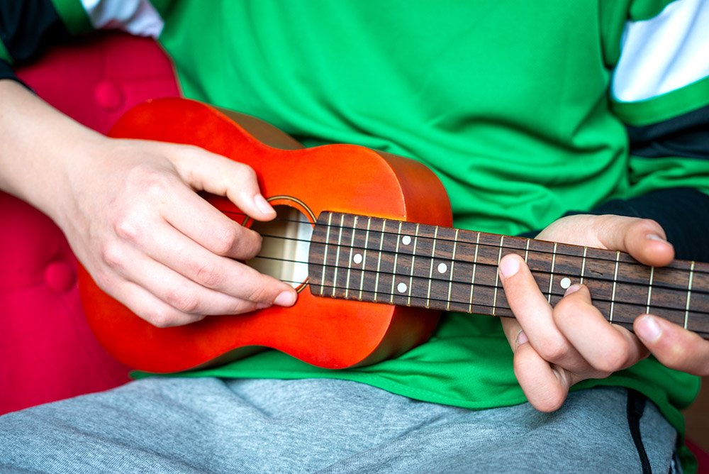 Teenage boy playing ukelele - Gifts for Teenage Grandchildren - Adventures in NanaLand